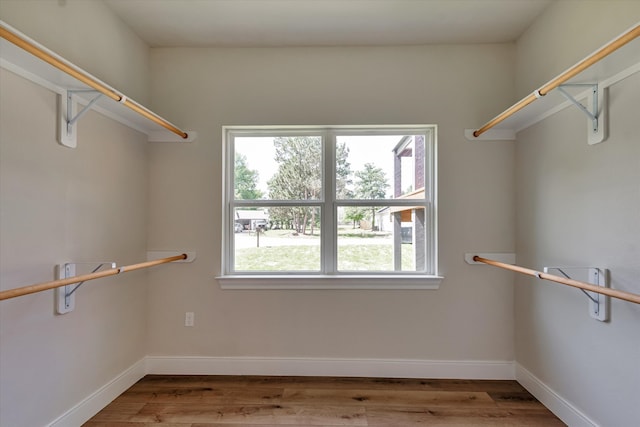 walk in closet with light hardwood / wood-style floors