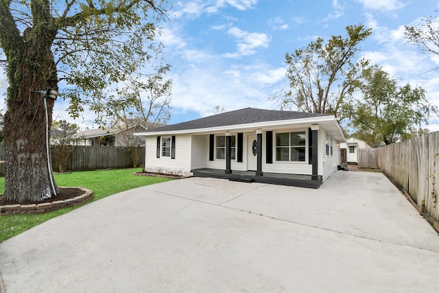 ranch-style house featuring covered porch and a front lawn