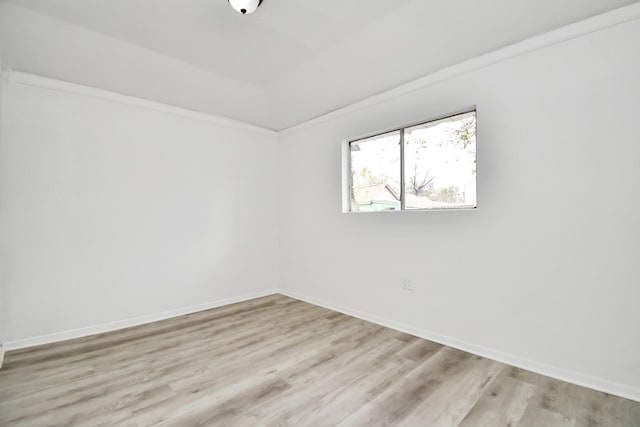 unfurnished room with light wood-type flooring and crown molding