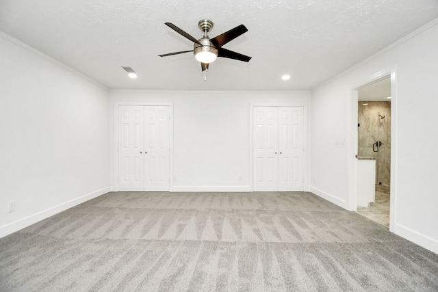 empty room featuring a textured ceiling, light colored carpet, and ceiling fan