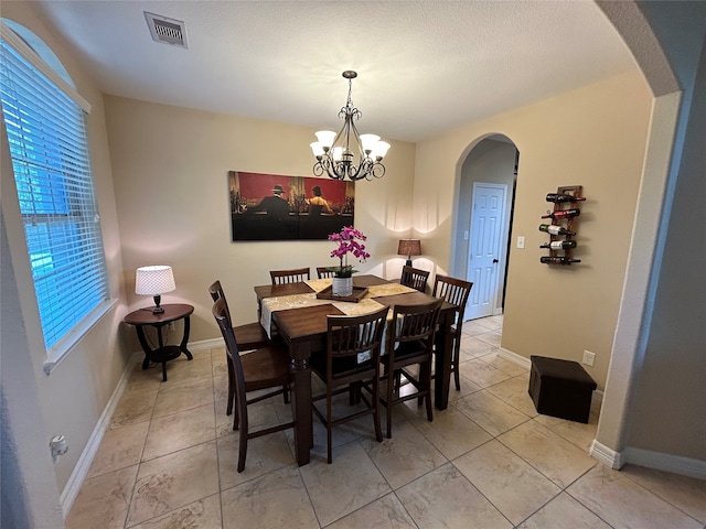 dining area featuring a wealth of natural light and an inviting chandelier