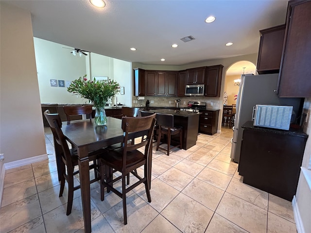 tiled dining room featuring ceiling fan