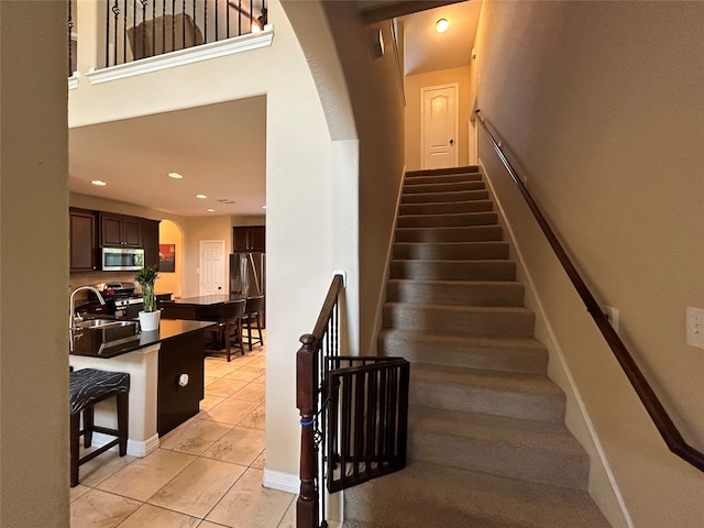 stairway featuring tile patterned floors and sink