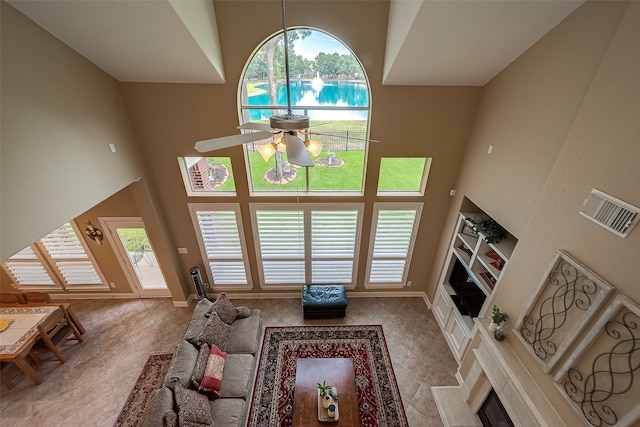 living room with a high ceiling, a wealth of natural light, and ceiling fan