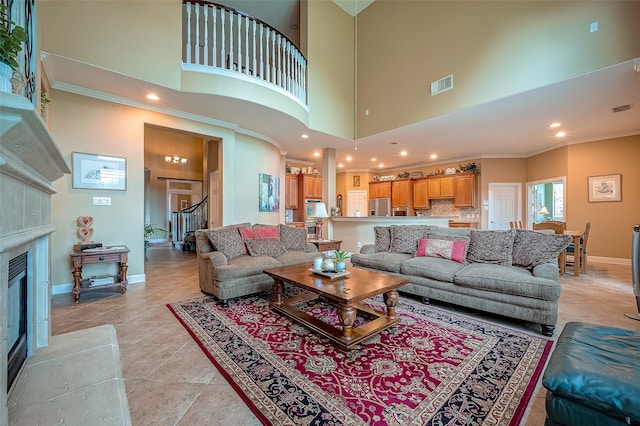 tiled living room with a tile fireplace, a towering ceiling, and ornamental molding