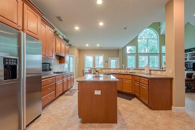 kitchen with a center island, sink, built in appliances, tasteful backsplash, and kitchen peninsula