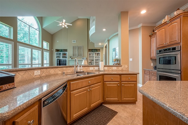 kitchen with decorative backsplash, stainless steel appliances, crown molding, sink, and light tile patterned floors