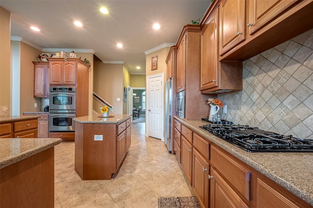 kitchen featuring light stone counters, backsplash, crown molding, a kitchen island, and appliances with stainless steel finishes