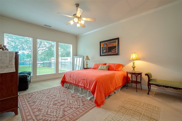 bedroom with carpet, ceiling fan, and crown molding