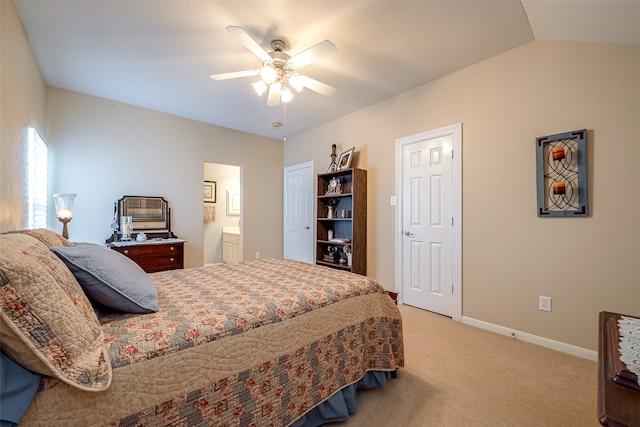 bedroom featuring ensuite bath, ceiling fan, light colored carpet, and vaulted ceiling