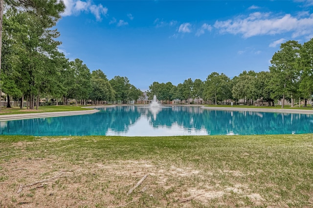 view of swimming pool with a lawn and a water view