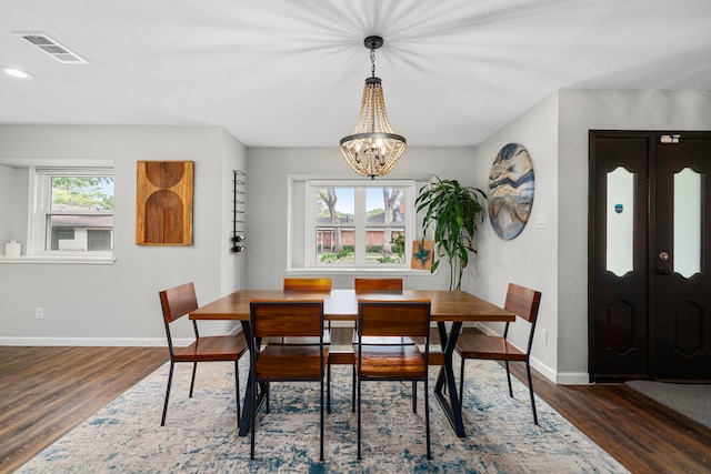 dining space featuring dark hardwood / wood-style flooring and an inviting chandelier