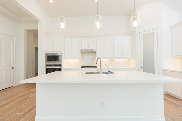 kitchen with white cabinets, sink, and a kitchen island with sink