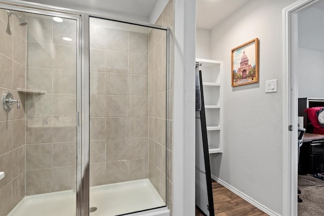 bathroom with hardwood / wood-style flooring and an enclosed shower