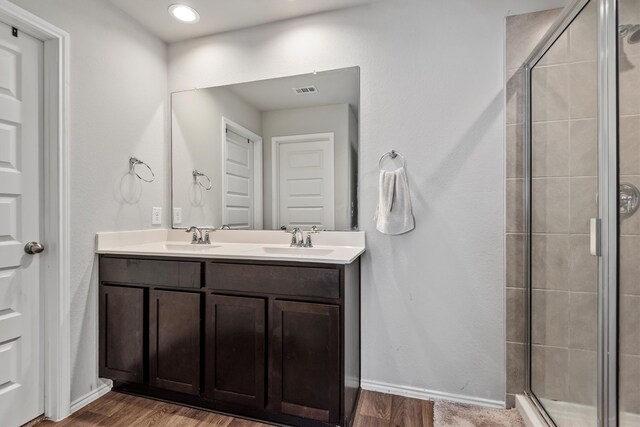 bathroom featuring walk in shower, vanity, and hardwood / wood-style floors