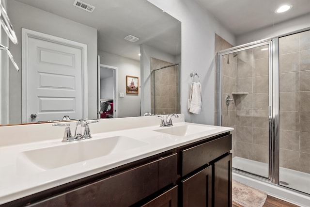 bathroom with walk in shower, vanity, and hardwood / wood-style flooring