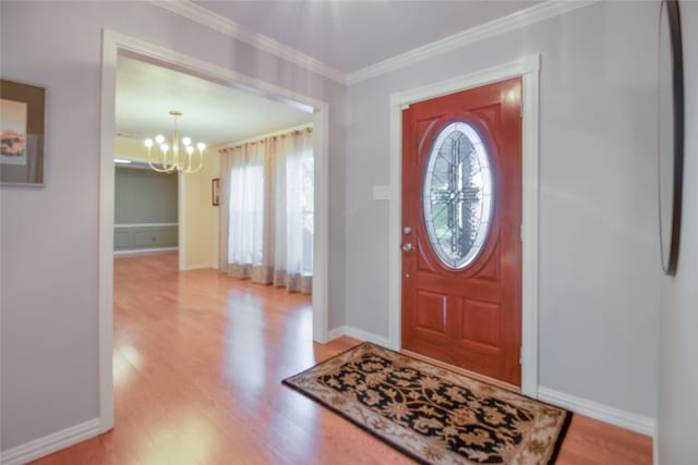 entryway featuring crown molding, an inviting chandelier, and light wood-type flooring