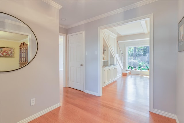 corridor with stairway, baseboards, light wood-type flooring, and ornamental molding