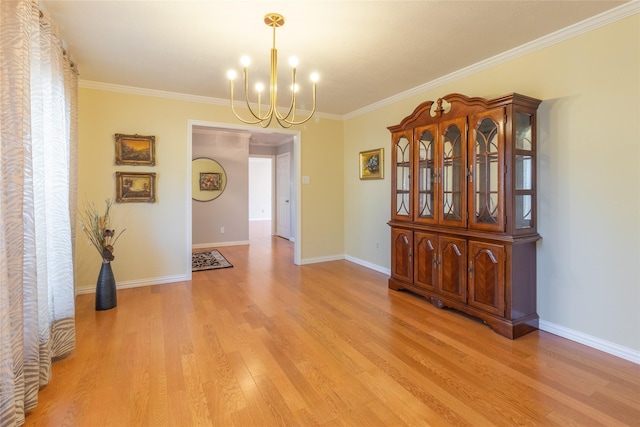 unfurnished dining area with ornamental molding, a chandelier, and light hardwood / wood-style floors