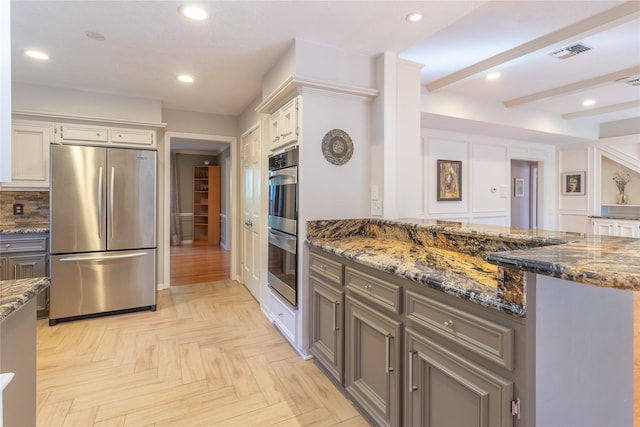 kitchen featuring gray cabinets, white cabinetry, dark stone counters, stainless steel appliances, and light parquet flooring