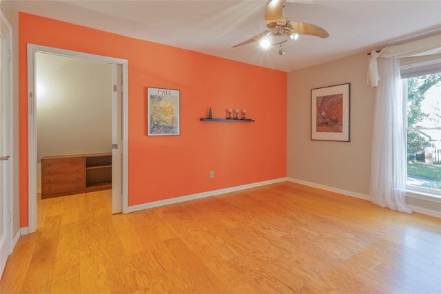 empty room with ceiling fan and light wood-type flooring