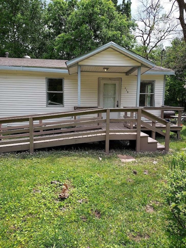 back of house featuring a wooden deck and a yard