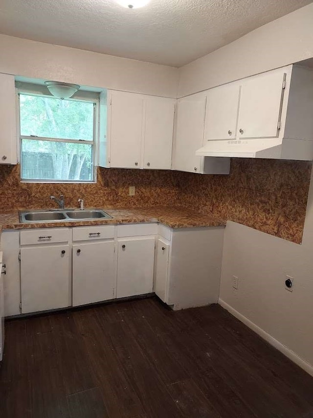 kitchen with tasteful backsplash, a textured ceiling, dark wood-type flooring, sink, and white cabinetry