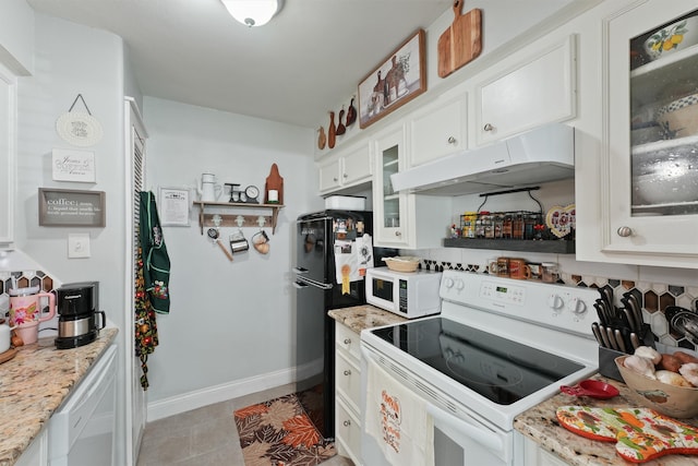 kitchen with light stone countertops, white appliances, white cabinetry, and light tile patterned flooring