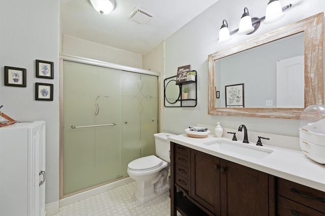 bathroom featuring a shower with door, vanity, and toilet