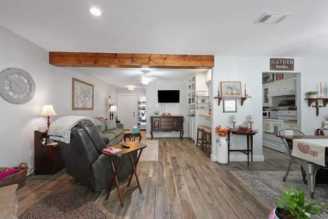 living room with ceiling fan, beam ceiling, and wood-type flooring