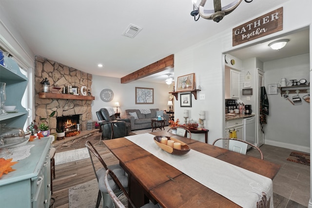 dining area with a stone fireplace and dark hardwood / wood-style flooring