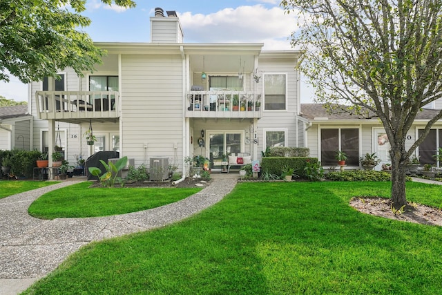 townhome / multi-family property featuring a balcony, a front lawn, and central air condition unit