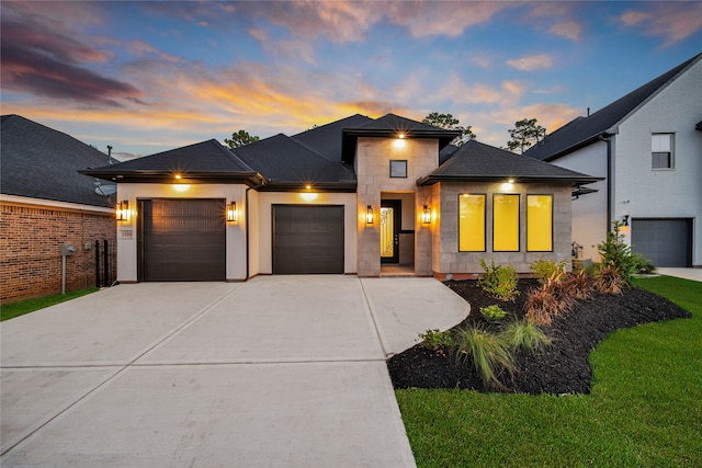 prairie-style house featuring a yard and a garage