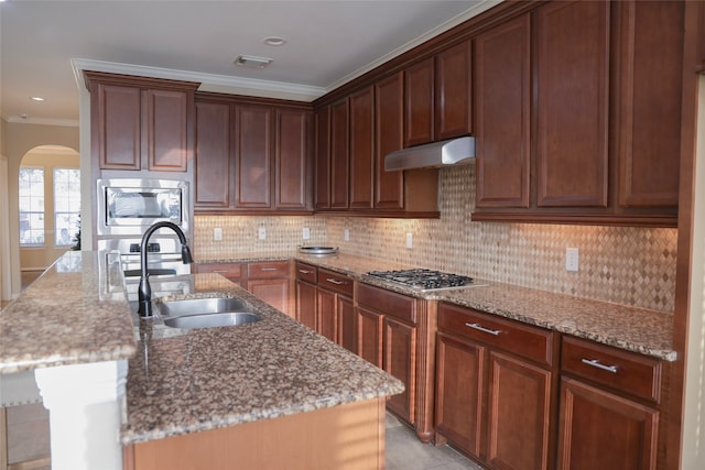 kitchen featuring appliances with stainless steel finishes, an island with sink, crown molding, and sink