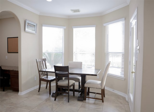 dining space with ornamental molding and light tile patterned floors