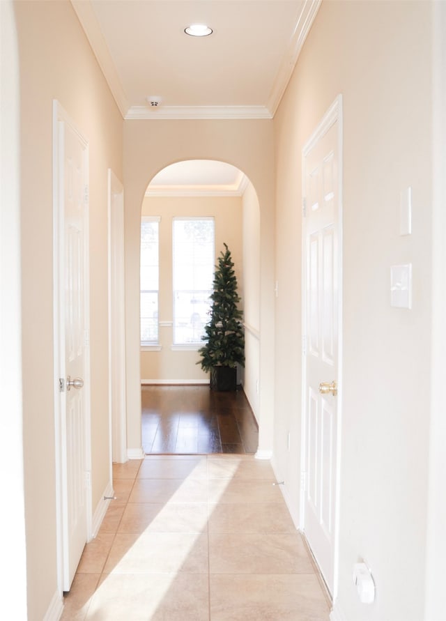 hallway with light wood-type flooring and ornamental molding