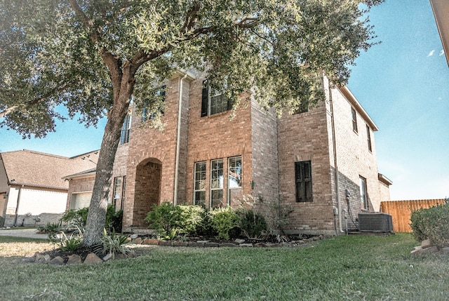 view of front of property featuring a front lawn and cooling unit