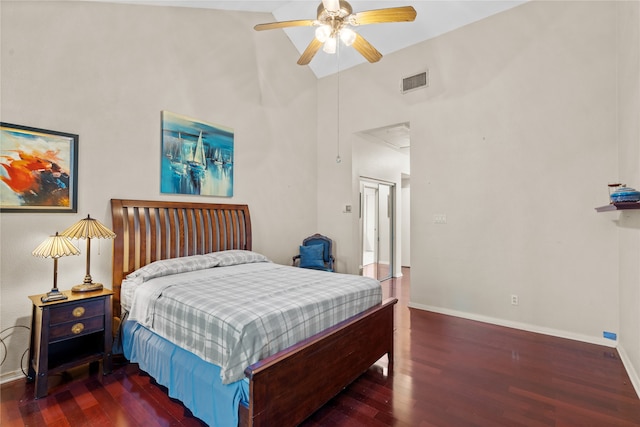 bedroom featuring ceiling fan, dark hardwood / wood-style flooring, and a high ceiling