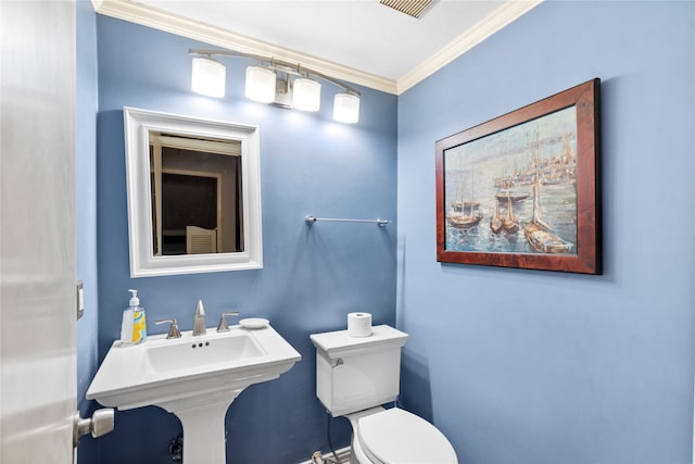 bathroom with toilet, ornamental molding, and sink