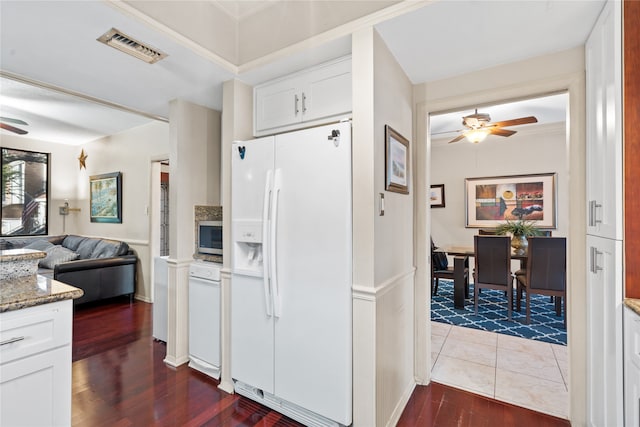 kitchen with hardwood / wood-style floors, white cabinets, and white refrigerator with ice dispenser