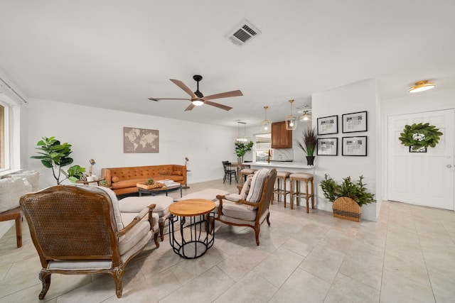 living room with ceiling fan, plenty of natural light, and light tile patterned floors