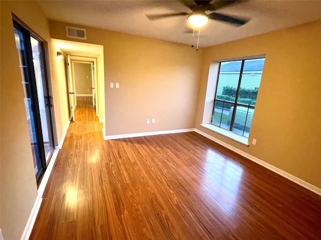 empty room featuring ceiling fan, light hardwood / wood-style flooring, and a textured ceiling