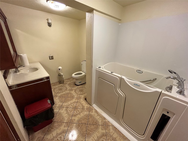 bathroom with tile patterned floors, vanity, toilet, and a washtub