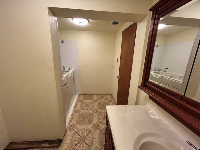 bathroom featuring vanity, separate washer and dryer, and tile patterned floors