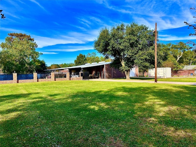 8766 Beauxart Garden Rd, Beaumont, TX 77705 - view of front facade featuring fence, a front lawn, an outdoor structure, and an outbuilding