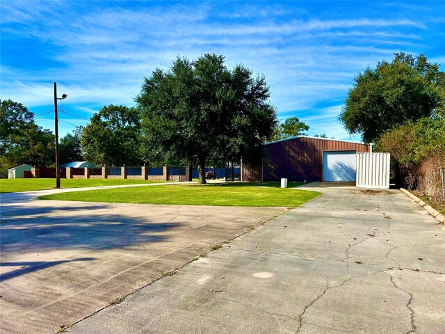 8766 Beauxart Garden Rd, Beaumont, TX 77705 - exterior space featuring a garage, a yard, an outbuilding, and driveway