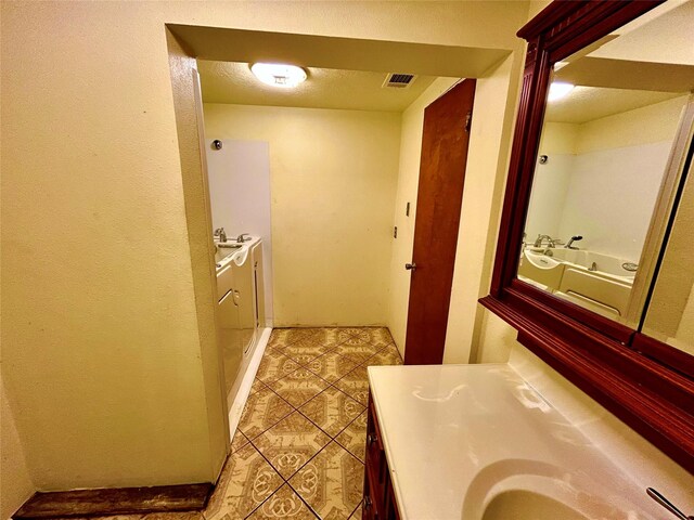 8766 Beauxart Garden Rd, Beaumont, TX 77705 - full bath featuring separate washer and dryer, tile patterned floors, visible vents, and vanity