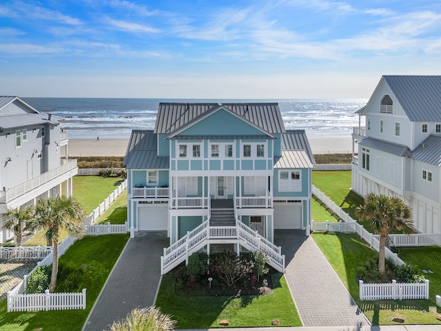 exterior space with a water view, covered porch, and a beach view