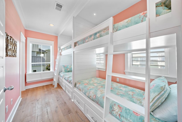 bedroom with light wood-type flooring and crown molding