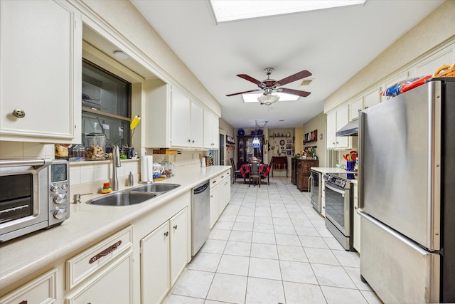 kitchen featuring stainless steel appliances, ceiling fan, sink, light tile patterned floors, and range hood